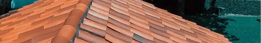 Residential clay tile roof with ridge caps, providing long-lasting durability to protect and preserve roofing from weather damage.