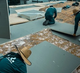 A team of professional contractors installing insulation panels as part of comprehensive roof repair services.