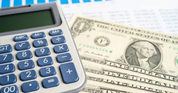 Calculator and money representing a Professional Roof Replacement Done Right estimate