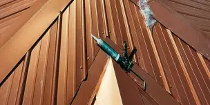 Graphic illustration showing sun rays reflecting off a green roof, highlighting the heat resistance and energy efficiency benefits of a quality metal roof repair service.