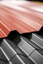 Professional roofer securing the ridge cap with fasteners during a comprehensive metal roof repair service on a green residential roof.