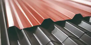 Overhead view of a green standing seam roof with custom white flashing applied around a brick chimney, highlighting quality metal roof repair service.