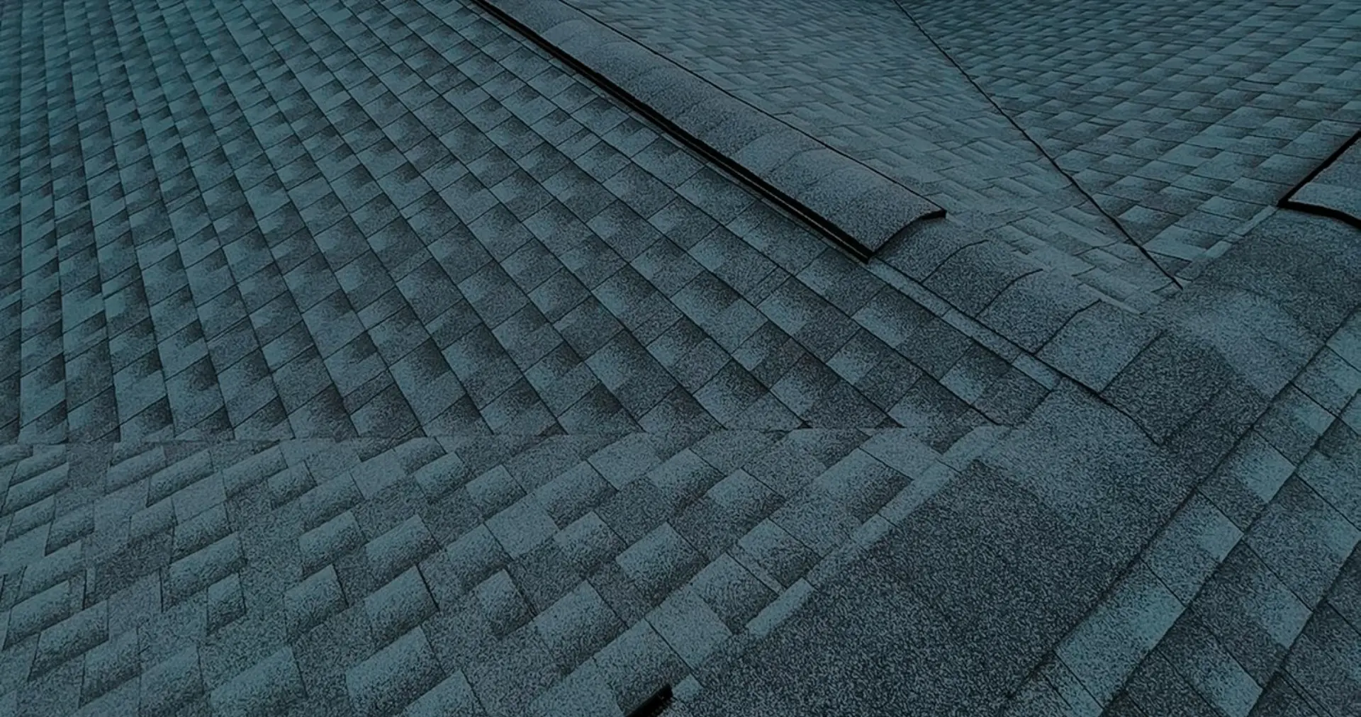 Vista aérea aproximada de um telhado de telhas asfálticas arquitetônicas recém concluído, demonstrando o acabamento profissional de qualidade dos new roof-services.