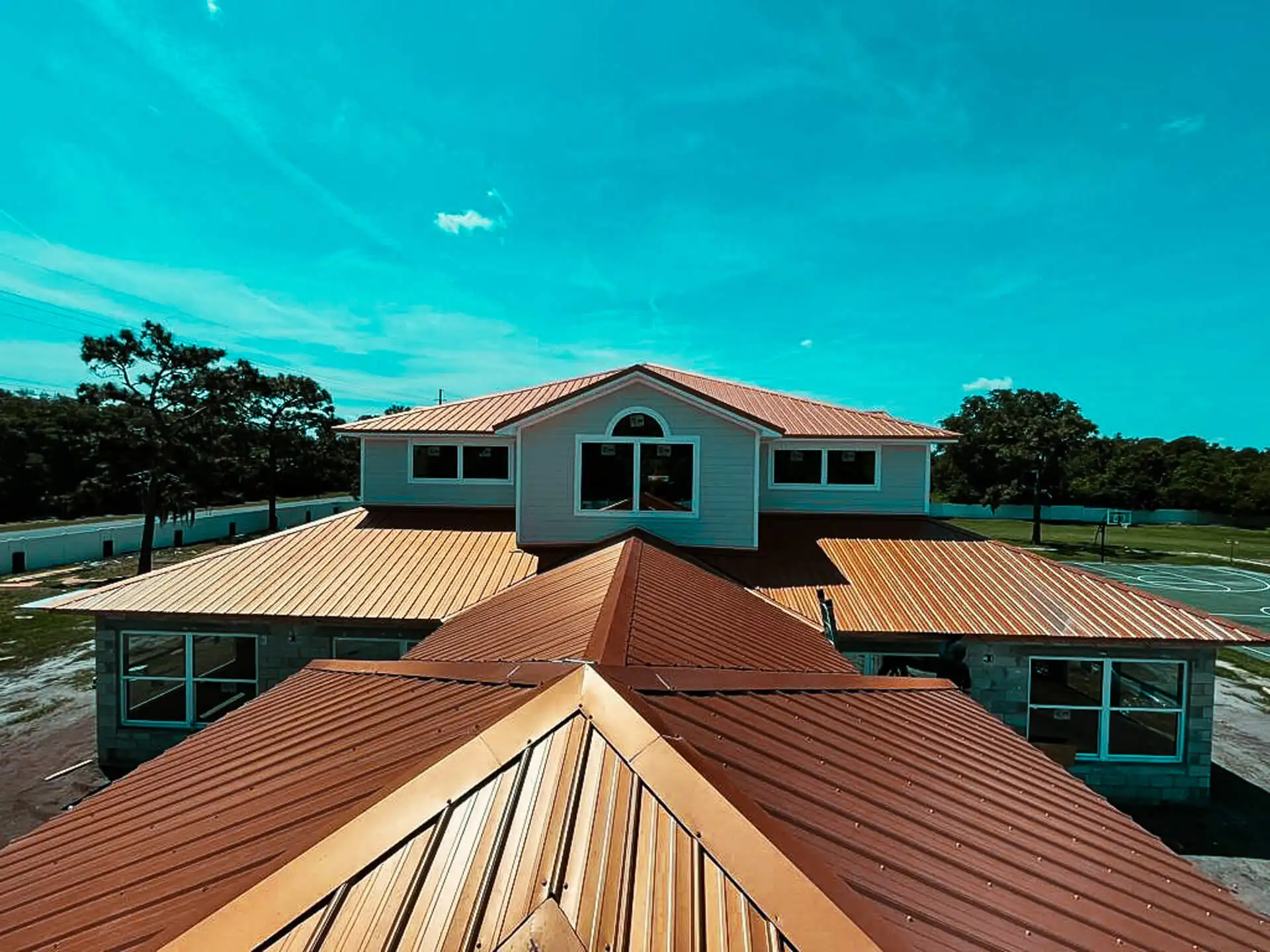 Large house with a brown metal roof providing durability and style, designed to protect preserve roofing against weather and time