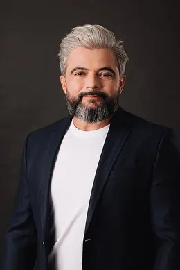 Portrait of the CEO of Protect Preserve Roofing wearing a dark blazer and white shirt.