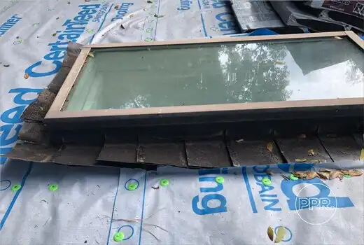 A skylight with damaged flashing, a common source of roof leaks, being prepared for repair or replacement by Protect Preserve Roofing.