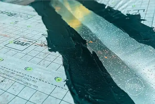 A close-up view of a roof valley being sealed with a waterproofing compound over GAF underlayment, showing a critical step in leak prevention by Protect Preserve Roofing.