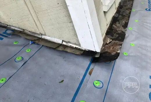 A close-up of damaged roof-to-wall flashing and new underlayment, showing a critical repair area handled by Protect Preserve Roofing.