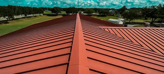 Top view of a new red standing seam metal roof, showing quality installation by a Roofing Company in Tampa.
