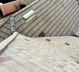 High angle view of a house roof showing different types of tiles as part of residential roof repair services.