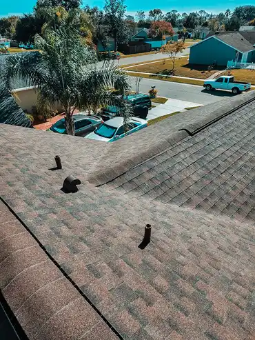 An aerial view of a residential shingle roof inspected by Protect Preserve Roofing, showing vents and surrounding neighborhood.