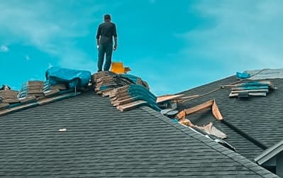A professional contractor standing on a high roof to inspect materials, representing reliable roofing companies in Clearwater.