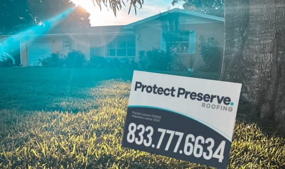 A local yard sign for Protect Preserve Roofing in front of a house, showcasing professional roofing companies in Clearwater.