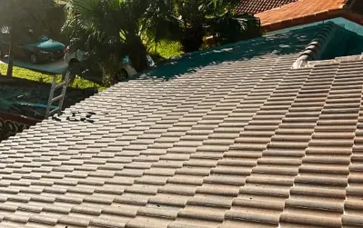 Newly installed tile roof on a residential home with palm trees in the background – project by our roofing company central florida.