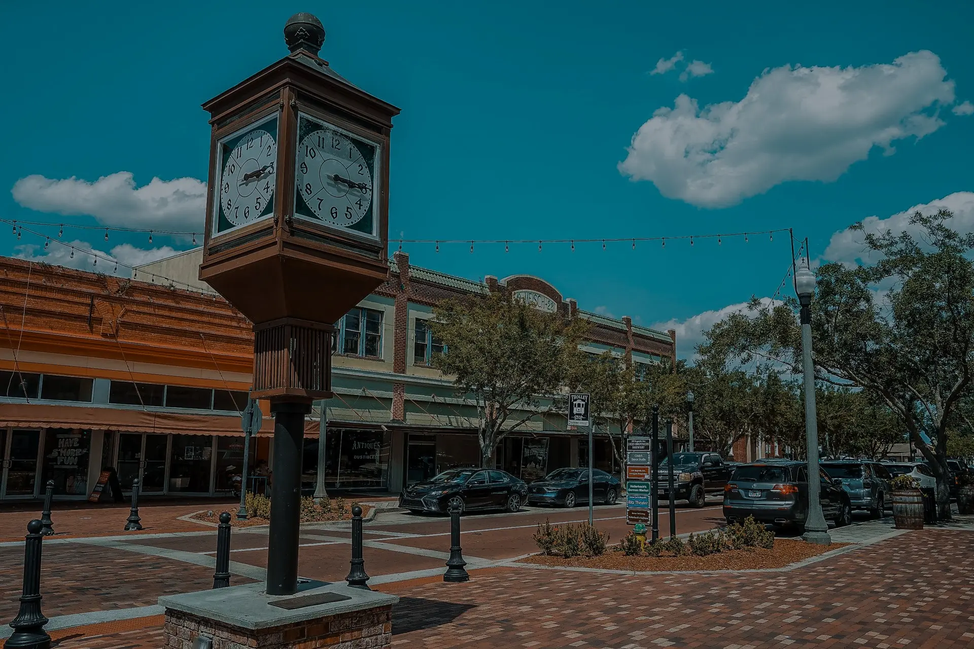 Historic street with a large clock tower, brick sidewalks, and local shops in downtown Sanford under a blue sky representing roofing company Sanford service area.