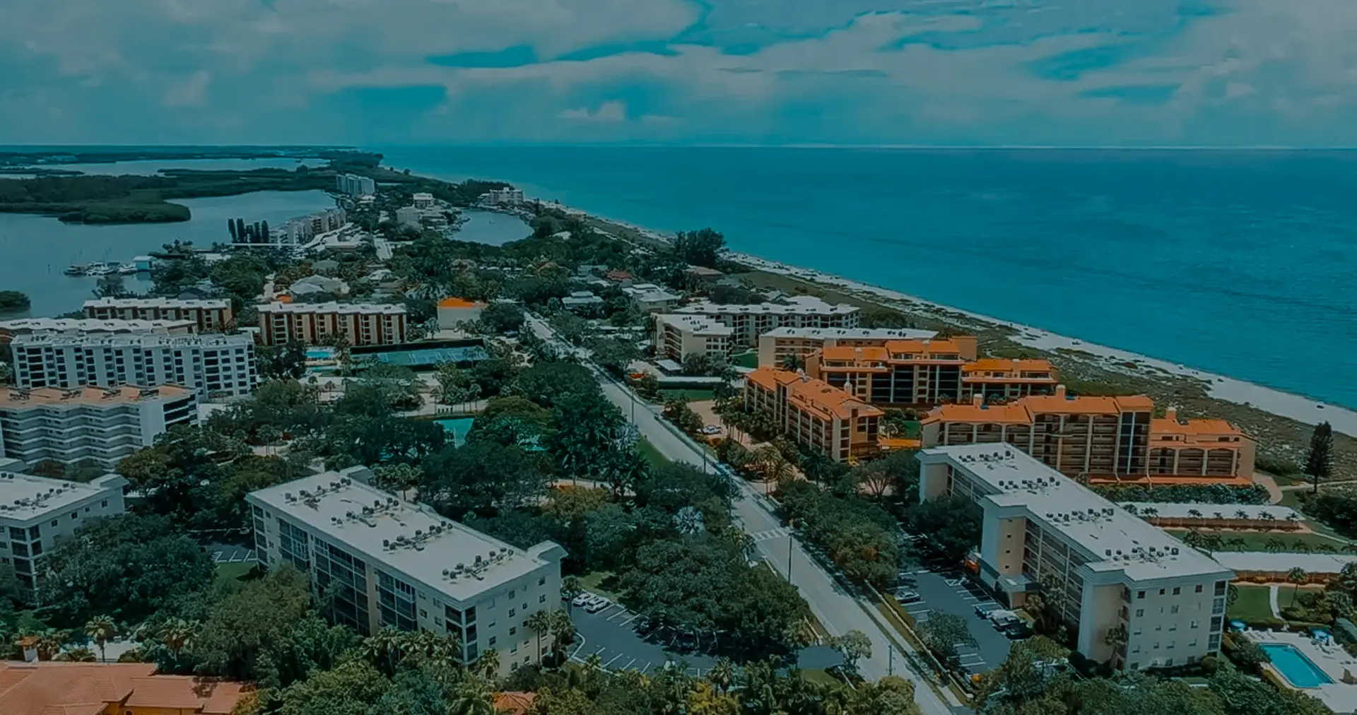 Aerial view of coastal residential buildings and condos along the beach – prime service area for our roofing company Sarasota.