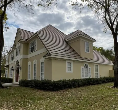 Large two-story house with a renovated brown tile roof, showcasing expert tile roof repair service.