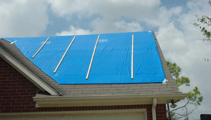 Roof of a house with a blue tarp installed to represent the keyword blue tarp installed.
