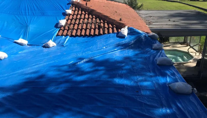 Roof covered with blue tarp to represent the keyword blue tarp roof benefits.