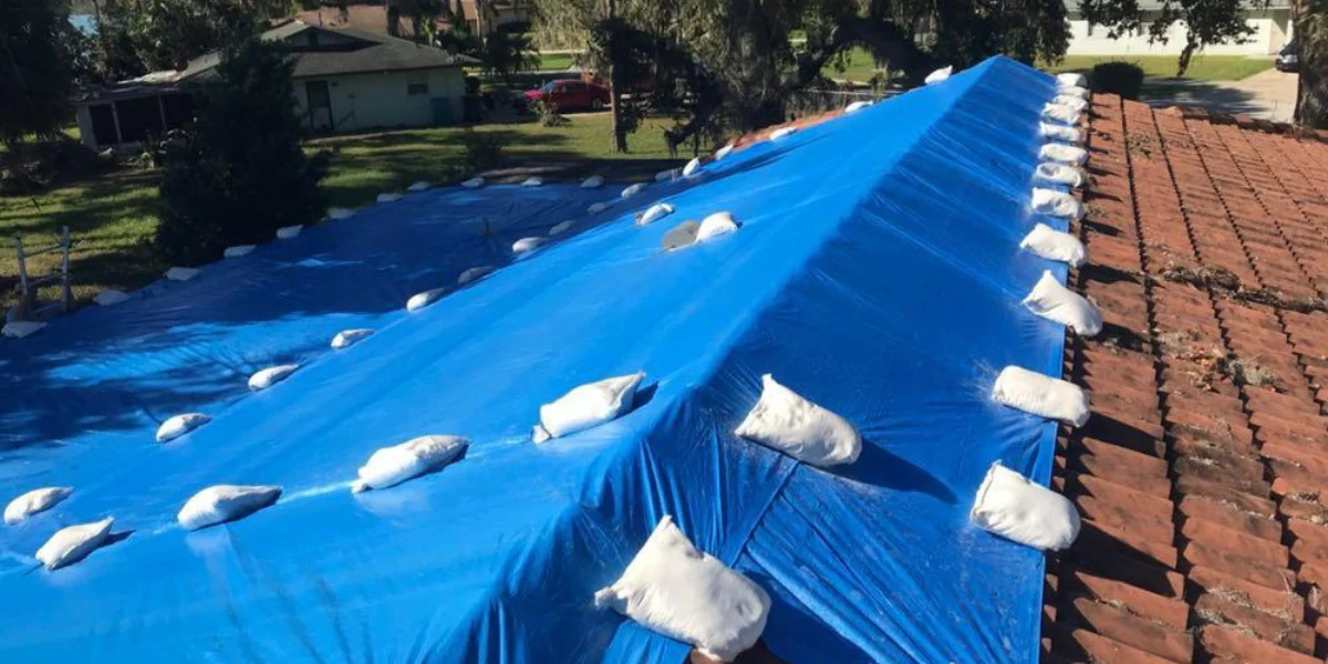 A roof with a blue tarp installed to represent the keyword blue tarp roof benefits.