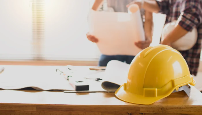 A table with papers and safety materials to represent the keyword roof replacement risks.