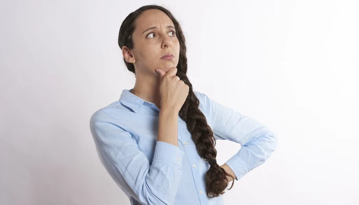 A woman with her hand on her chin indicating that she is thinking to represent the keyword thinking about blue tarp.