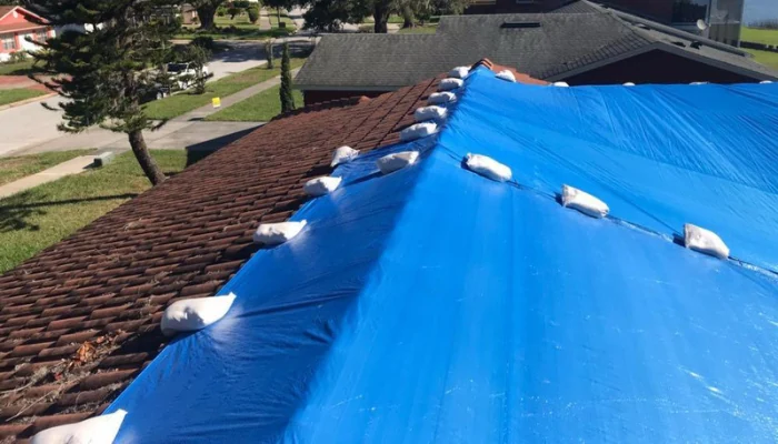 A blue tarp on a tile roof to represent the keyword best roof tarp is blue.