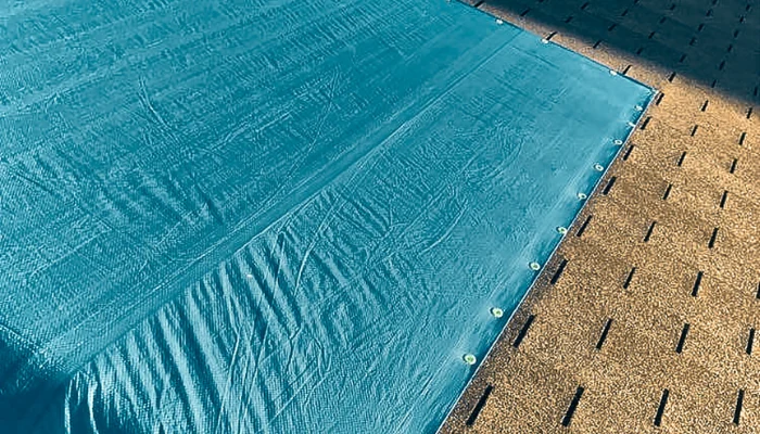 A roof with a blue tarp perfect installed to represent the keyword blue tarp is made of.