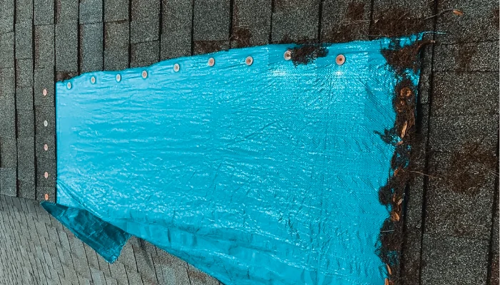 Blue tarp nailed incorreclty to the roof to represent the keyword roof damaged blue tarp.