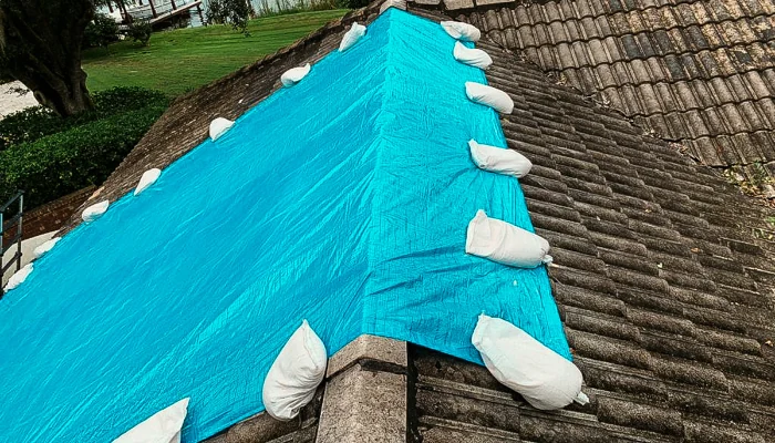 Blue tarp installed with sandbags to represent the keyword blue tarp installation.