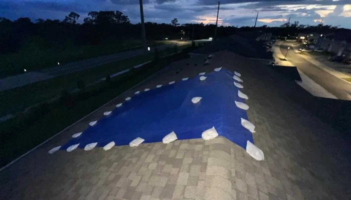A roof at night with a blue tarp installed to represent the keyword blue tarp installed at night.