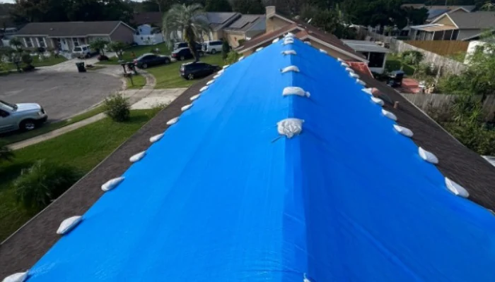 Blue tarp installed on a roof during the day to represent the keyword inspection blue roof.