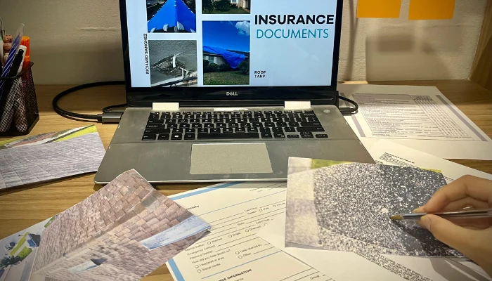 A table with a notebook and several papers to represent the keyword roof repair insurance information.