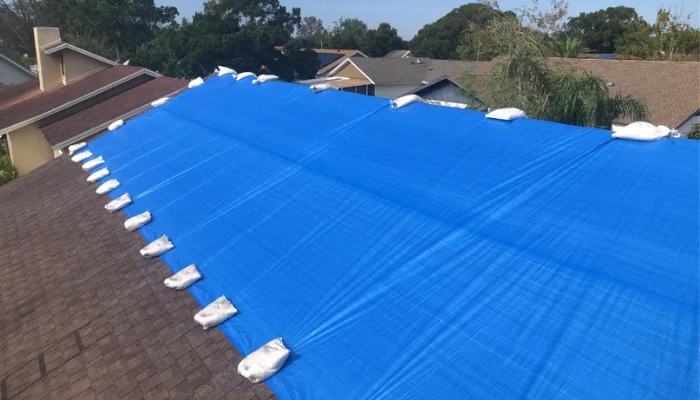 Blue tarp installed on a roof to represent the keyword tarp to prevent water damage.