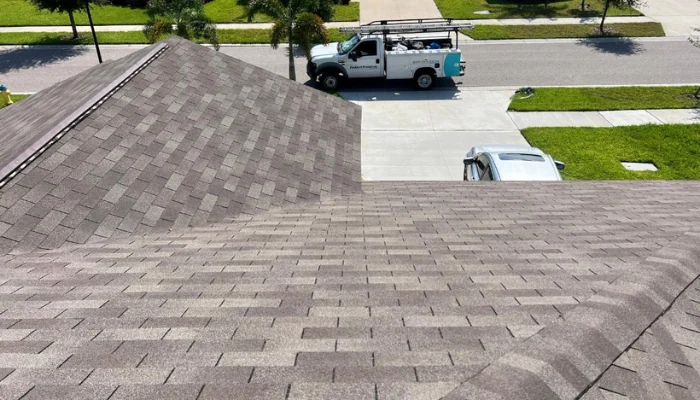 Finished roof seen from above with the street and a car in the background to represent the keyword architectural shingles.