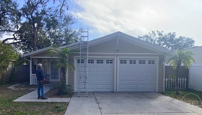 A house seen from the front with a ladder for roof repairs to represent the keyword average cost of a roof replacement.