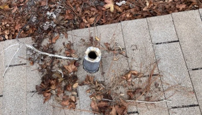 Pipe on a damaged roof to represent the keyword fire resistant roofing material.
