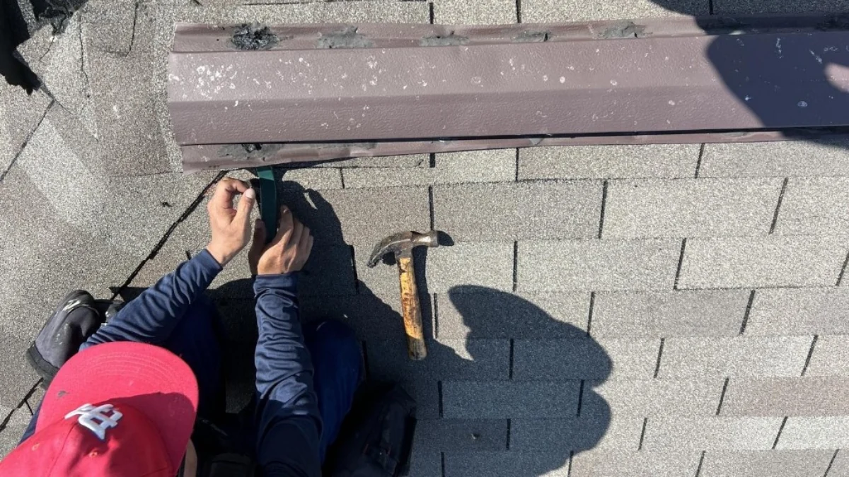 Man performing shingle repair on a roof to represent the keyword how much does an asphalt shingle roof cost.