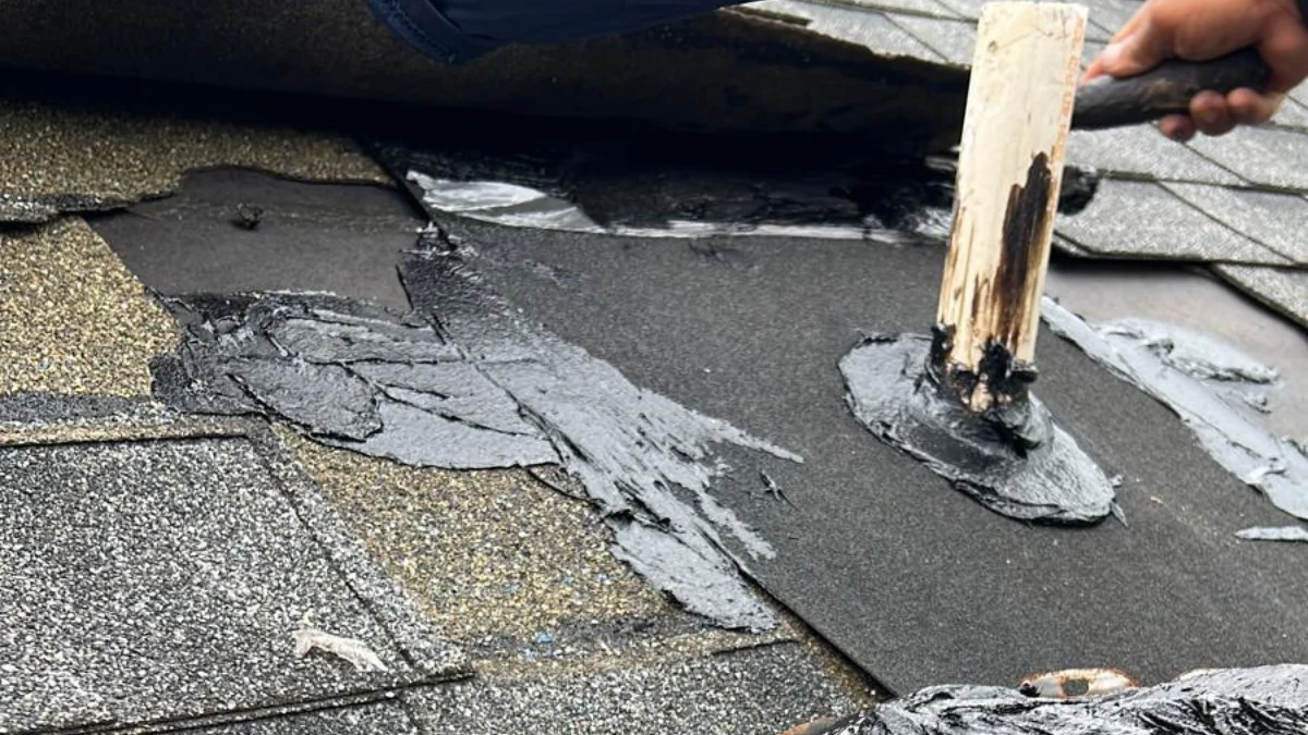 Sealant being put on shingles on a roof to represent the keyword how much is it to replace shingles on a roof.