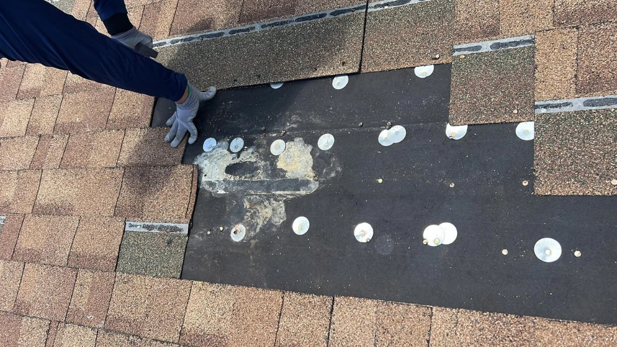 Man installing shingles on a roof to represent the keyword how to remove old asphalt shingles.