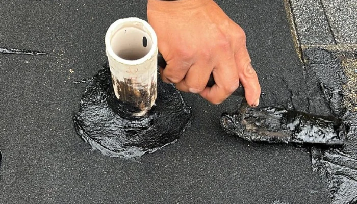 Installing shingle around a pipe to represent the keyword overlay asphalt shingle.