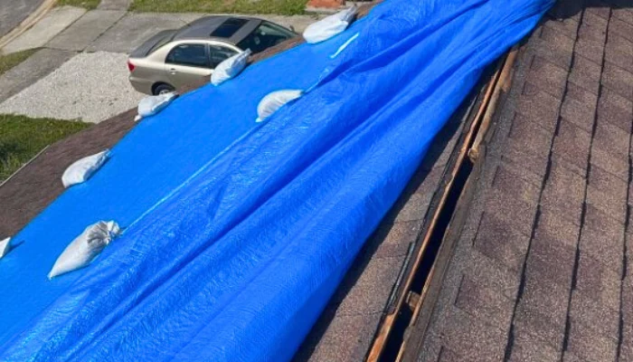 Blue tarp installed with sandbags to represent the keyword professionally installed blue tarp.