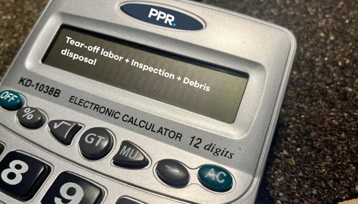 A gray calculator on a table to represent the keyword removing old asphalt shingles.