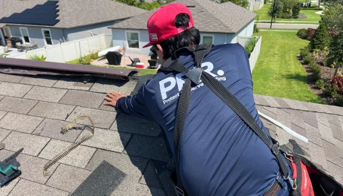 Man performing roof repair to represent keyword replace damaged shingles.