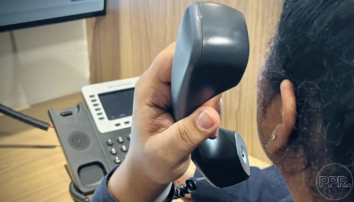 Woman holding a phone next to a table to represent the keyword replacing worn-out shingles.