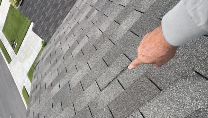 Man pointing to roof damage to represent keyword shingle repair.
