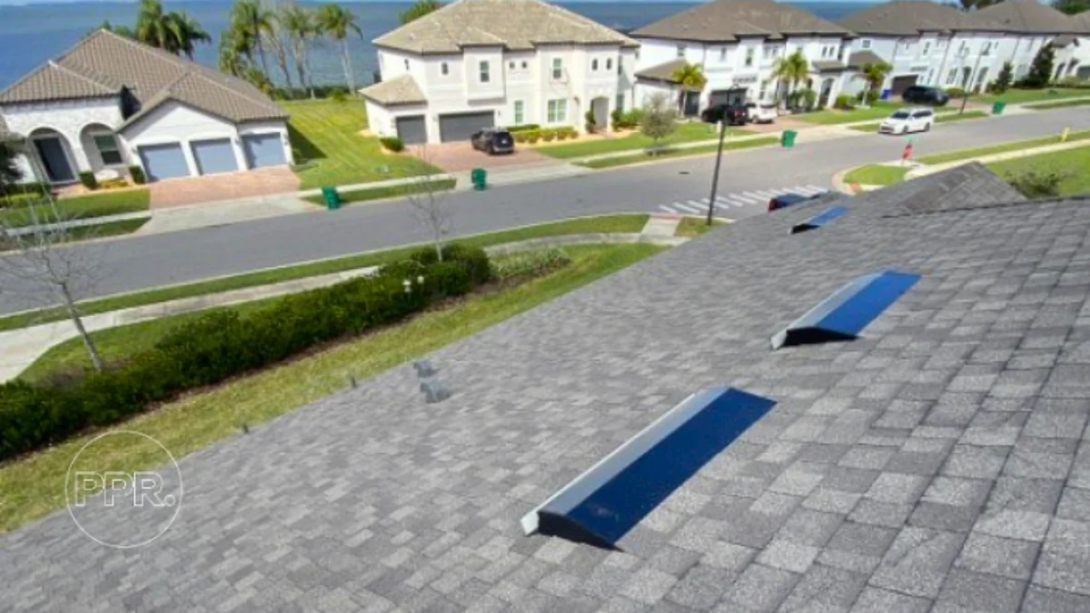 Shingle roof photographed from above with the street and other houses below to represent the keyword best asphalt roofing shingles.