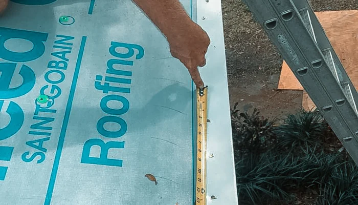 Drip edge being measured on a roof to represent the keyword drip edge.