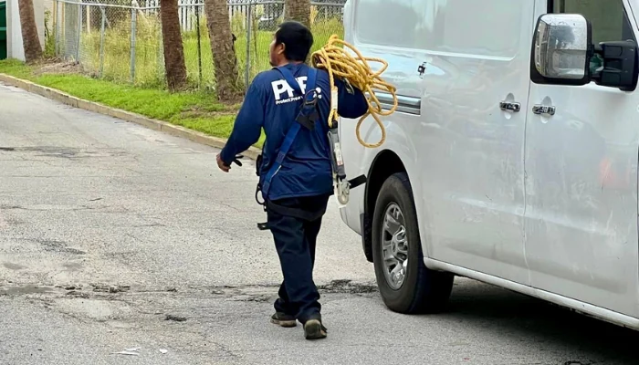 Man walking on street with roof repair material to represent keyword roofing contractor in florida.