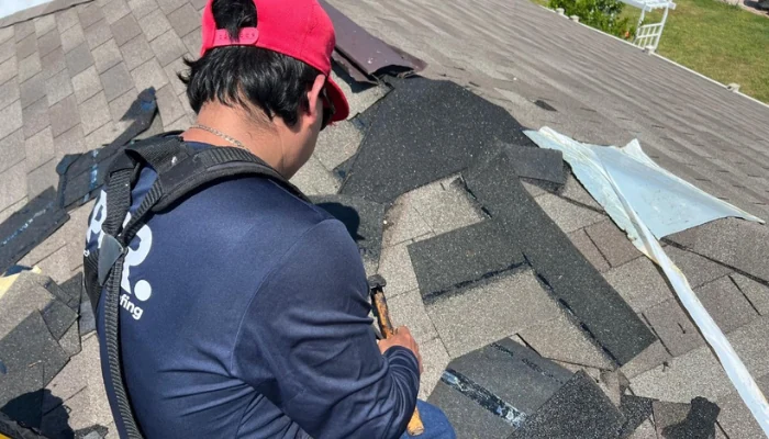 Man repairing a roof to represent the keyword signs of granular loss.